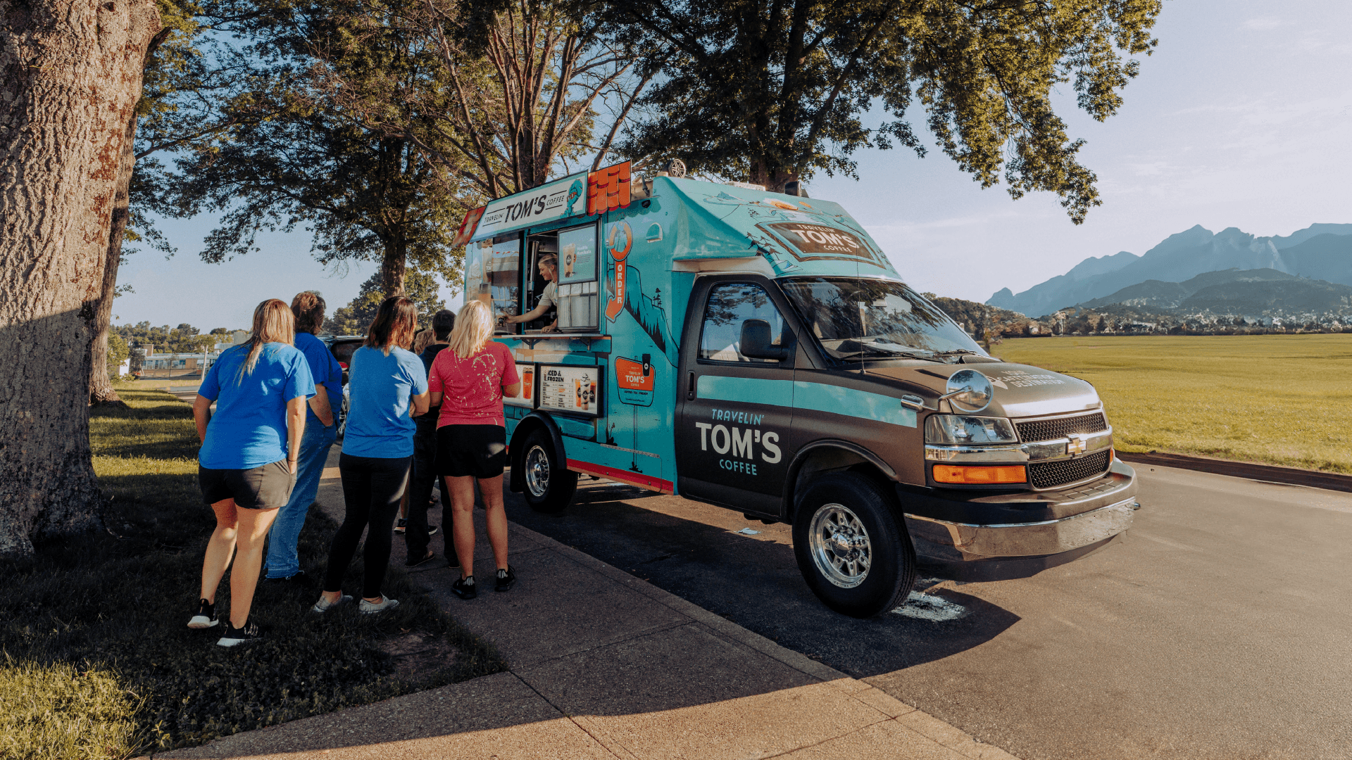 The Travelin' Tom's Coffee Truck parked outdoors with customers placing orders